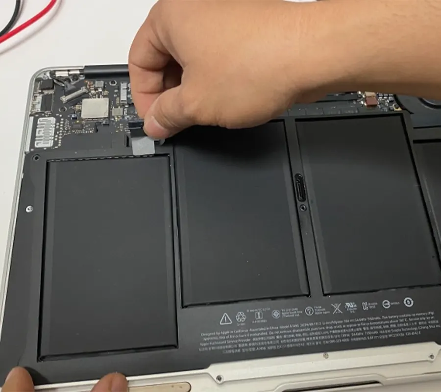 A guy disconnecting the battery connector from Macbook Air